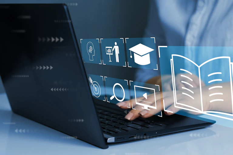 Hands seen at a laptop with digital icons floating.