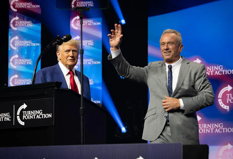 Robert F. Kennedy Jr. at a podium next to Donald Trump.