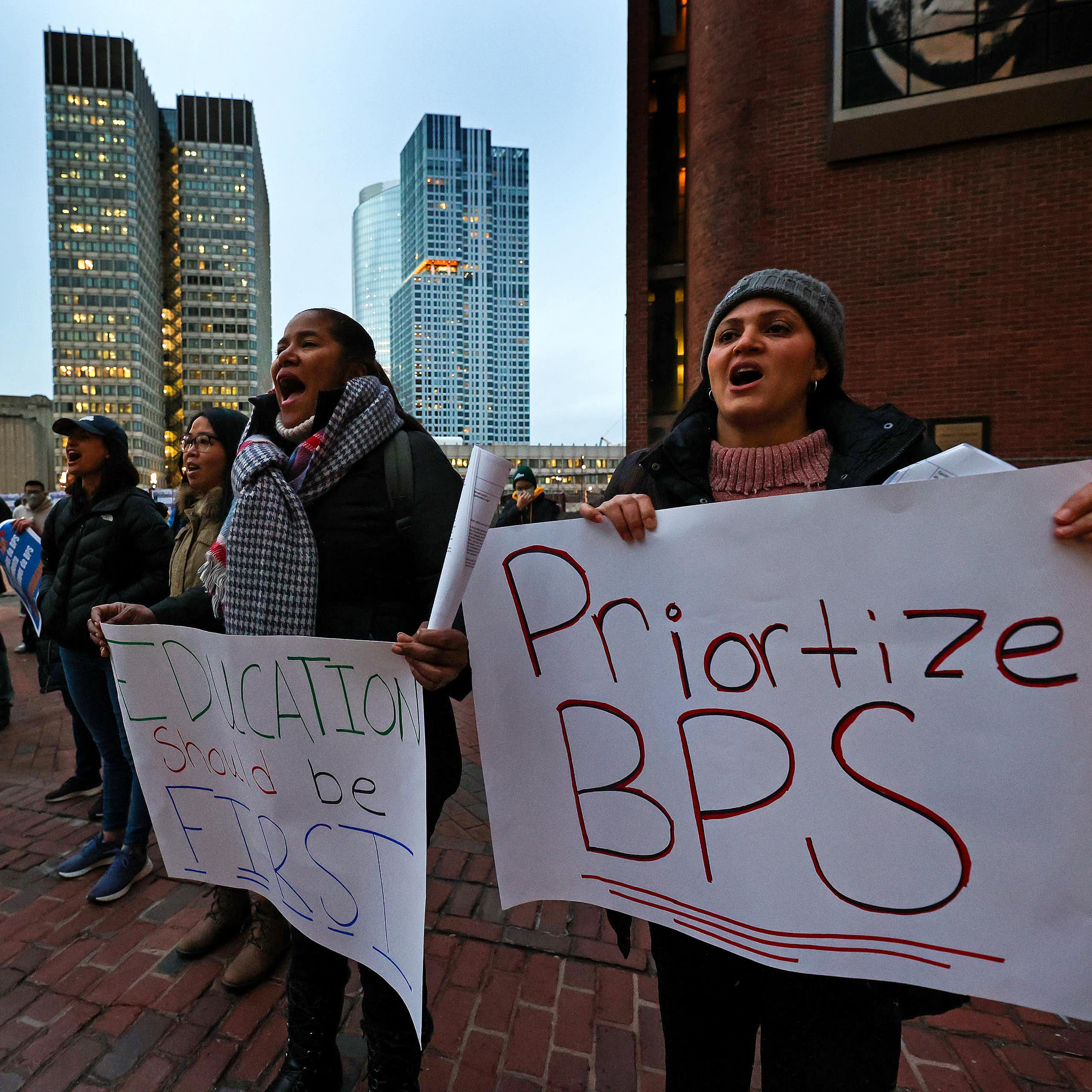 People hold signs reading 'Prioritize BPS' and 'Education should be first'