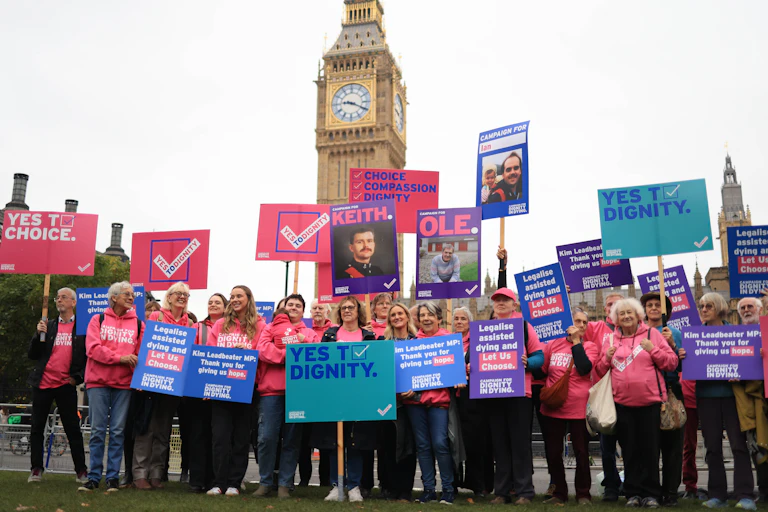Members of the Dignity in Dying campaign group and supporters gather outside the Palace of Westminster.