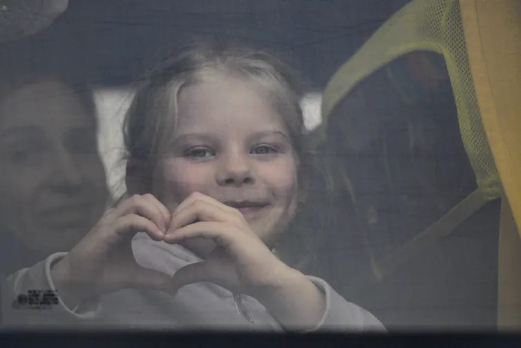 Une enfant fait un signe de cœur avec ses mains
