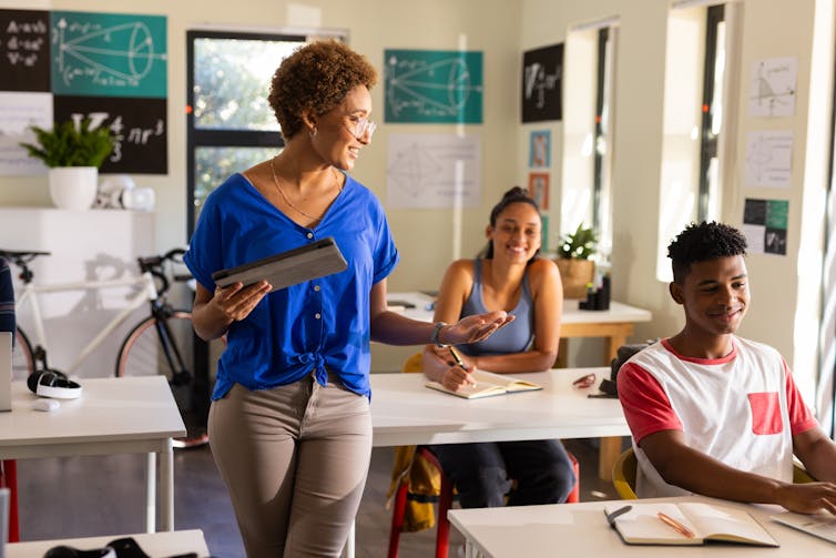 A teacher speaks to teenaged students in a classroom