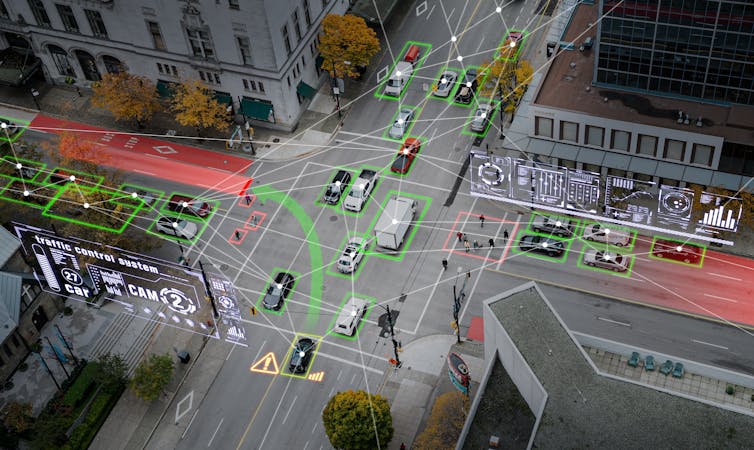 Overhead view of an illustrated, composite image of cars at an urban intersection, with lots of green and red lines and warnings overlaying to depict autonomous driving