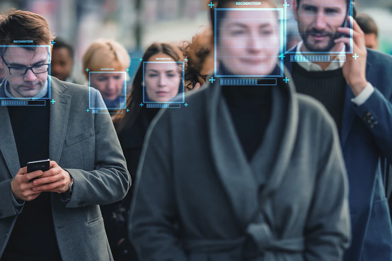 People walking in a crowd, with blue facial recognition squares over their faces
