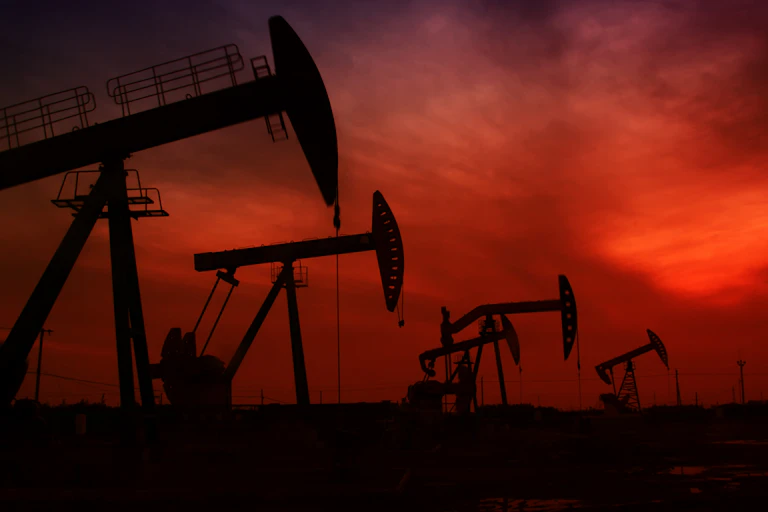 Small oil rigs against red sky
