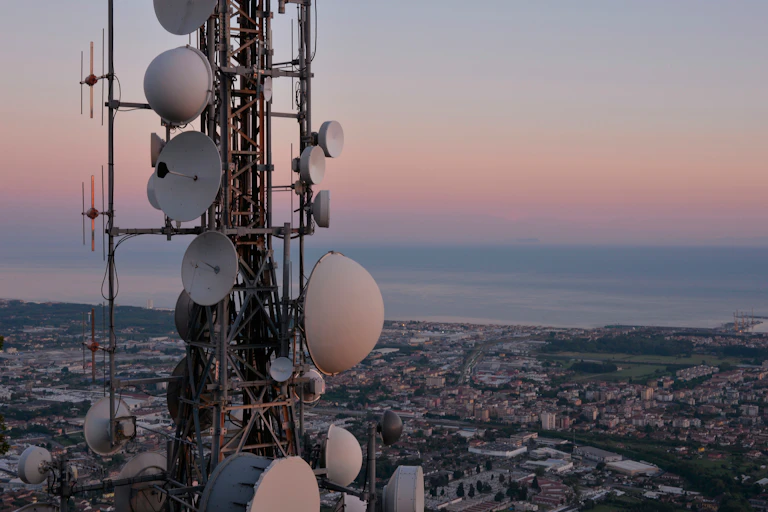 Une antenne relai surplombe une ville.