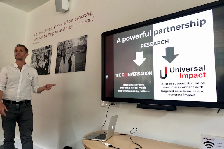 Man standing in front of a screen giving a lecture