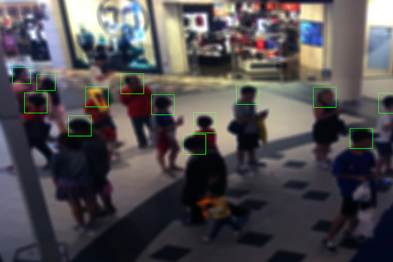monitor view displaying people in a shopping mall with squares outlining their faces