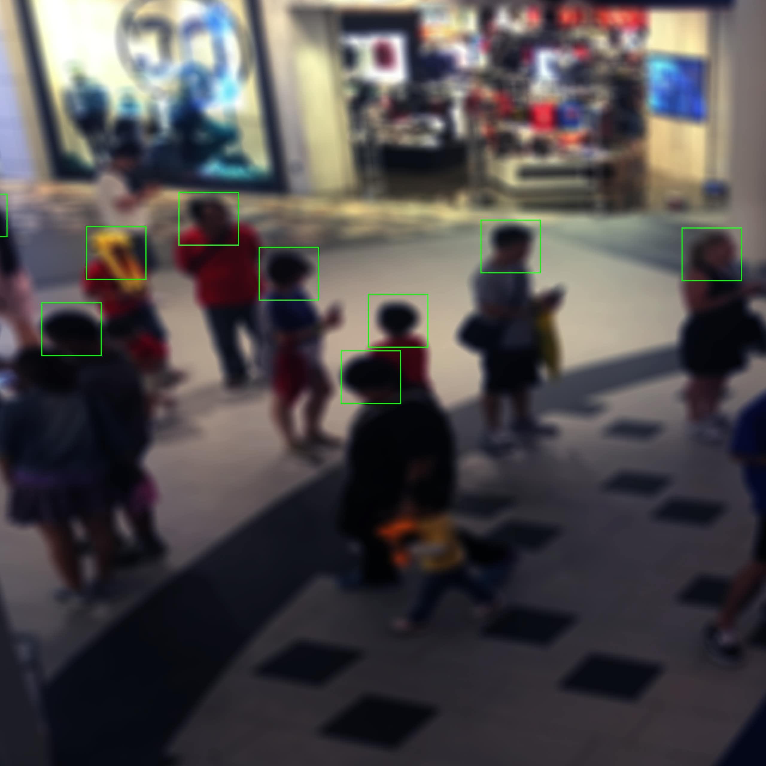 monitor view displaying people in a shopping mall with squares outlining their faces
