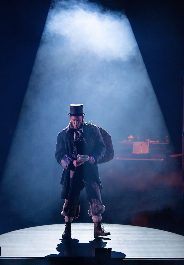 A man stands in a spotlight.