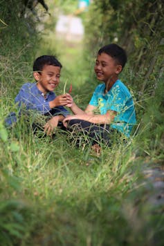 Two boys play in nature.
