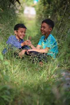 Two boys play in nature.
