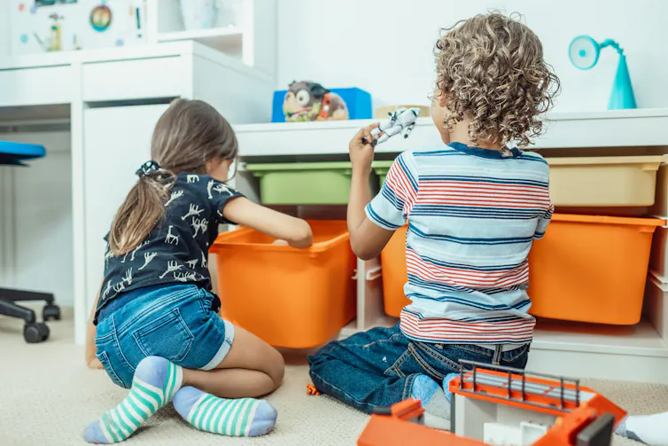 Two kids play cars.