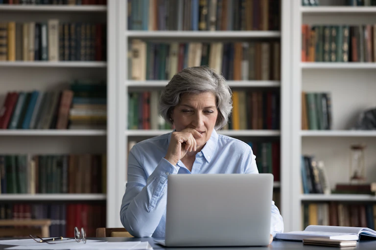 Woman looking at laptop thoughtfully