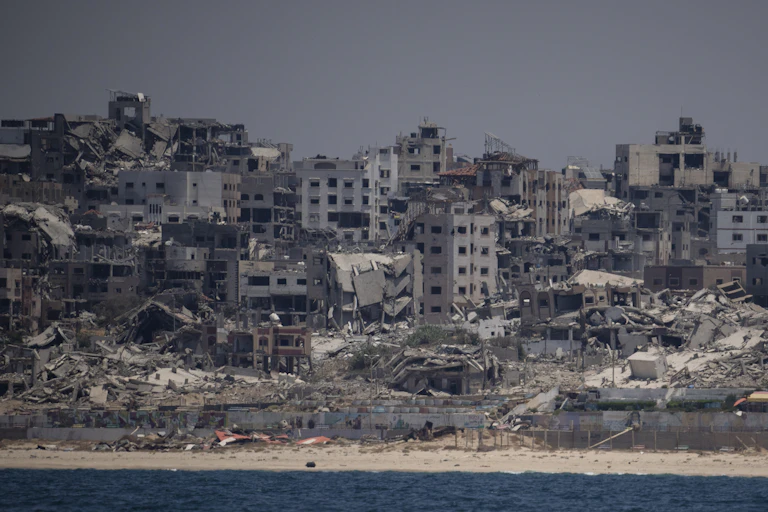 Rubble of destroyed buildings near other severely damaged buildings