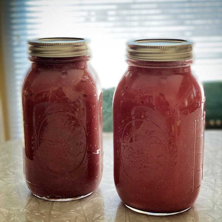 Two glass jars filled with dark pink gel.