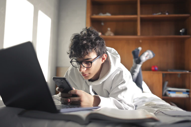 Teenaged boy looks at phone