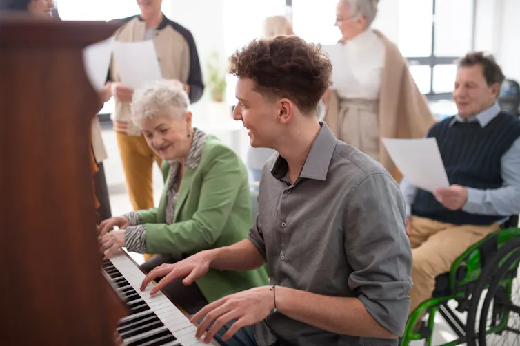An older woman and a younger man at a piano.