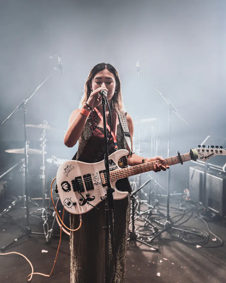 A woman with a guitar.