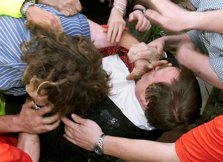 A man shoving his hand into John Prescott's face as they fight.
