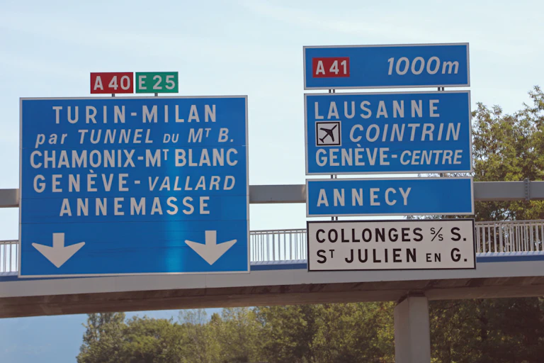 Des panneaux routiers indiquant la direction de villes en Suisse et en Italie.