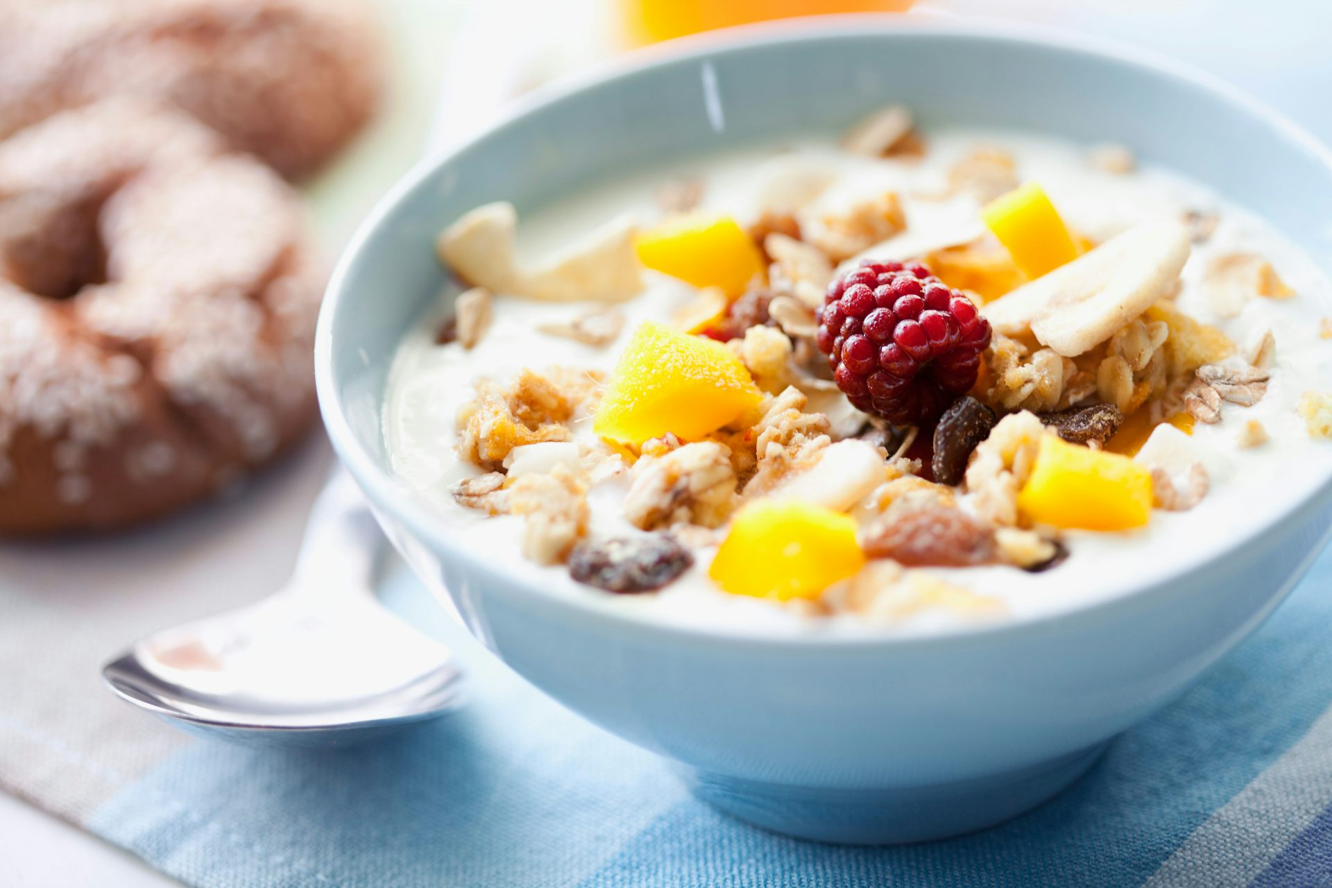 A bowl of cereal with fresh fruit on top.