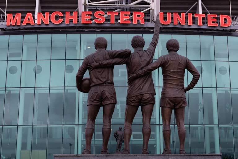 Statue of players at Old Trafford stadium.