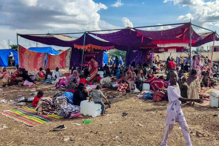 Des personnes sont assises et debout dans un camp pour personnes déplacées à Gedaref au Soudan.