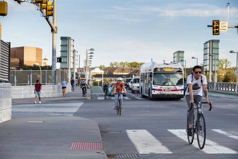Cyclists commuting on Philadelphia streets in front of city bus