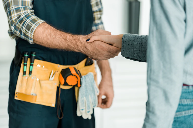 Tradesman shaking hands with a custome