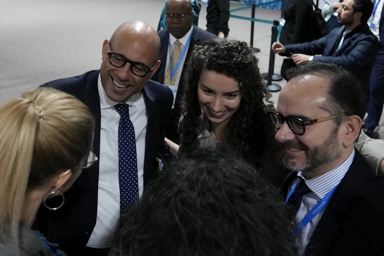 A group of people standing together in a circle, smiling.