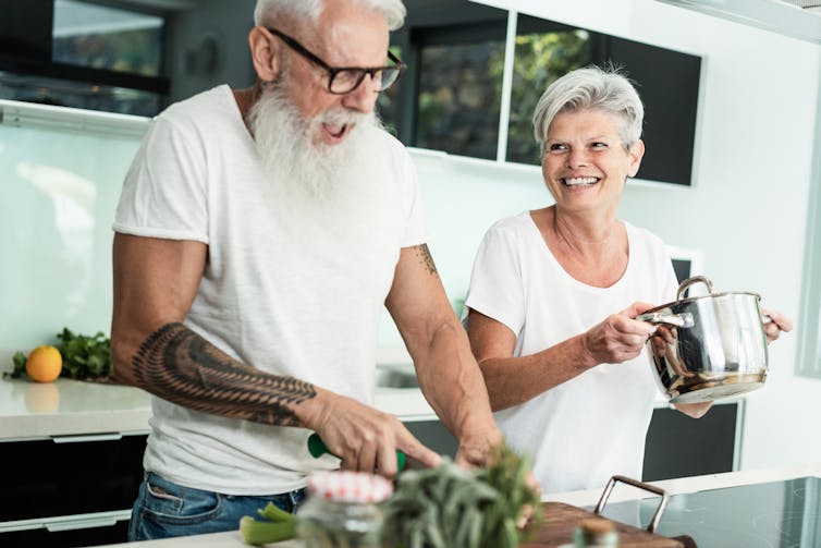 A middle-aged couple cooking.