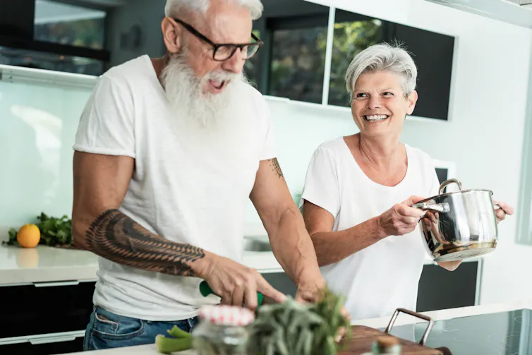 A middle-aged couple cooking.
