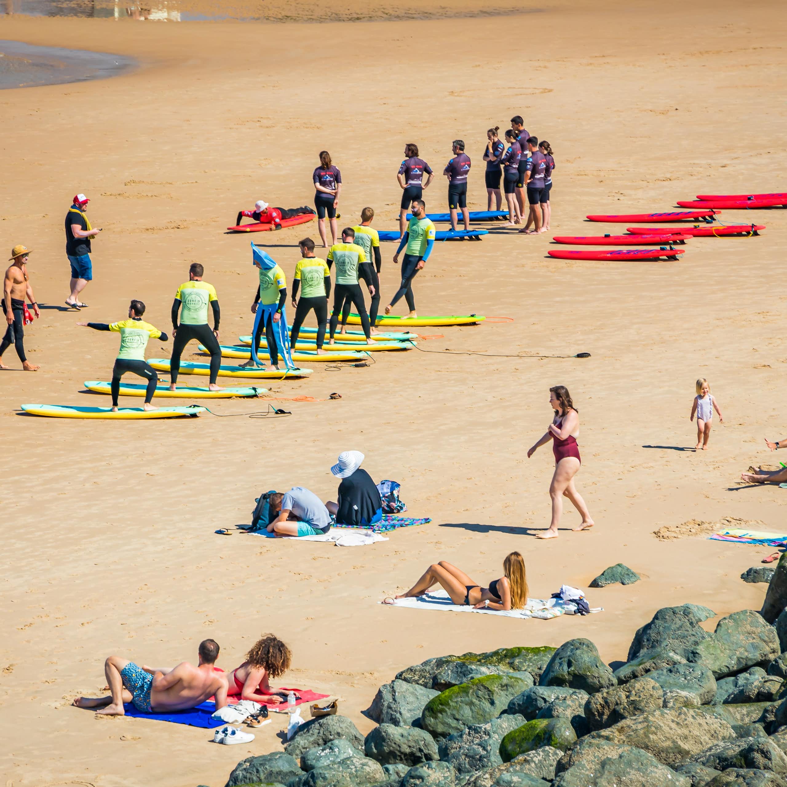 Surfing beginners learn surfing moves on a beach.