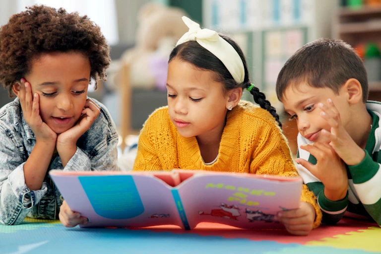 three children lying down reading