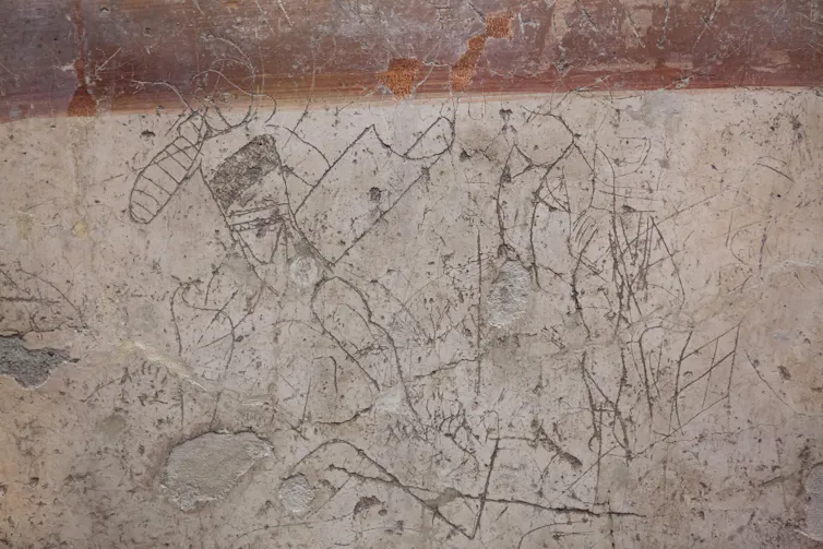 Scratched graffiti showing two gladiators fighting