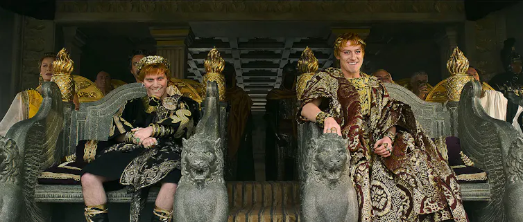 Fred Hechinger and Joseph Quinn in Roman dress, sat on thrones.