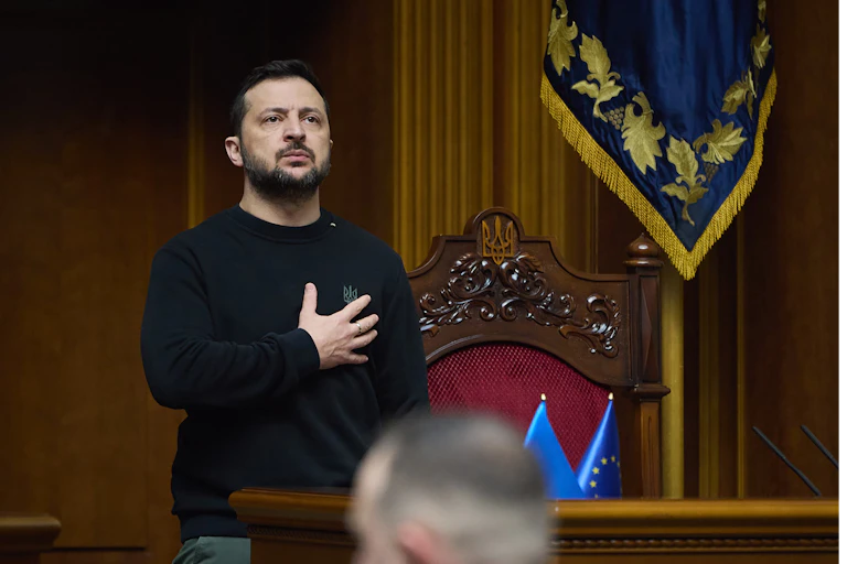 Ukrainian president Volodymyr Zelensky puts his hand over his heart.