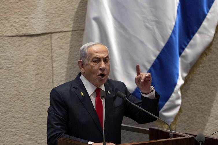 Politician stands speaking at podium