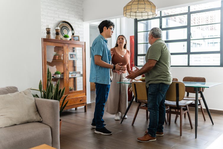 older man argues with younger man with older woman looking on