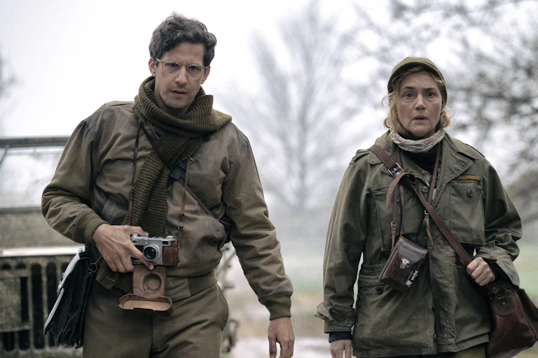 A man and woman in military clothing with cameras.