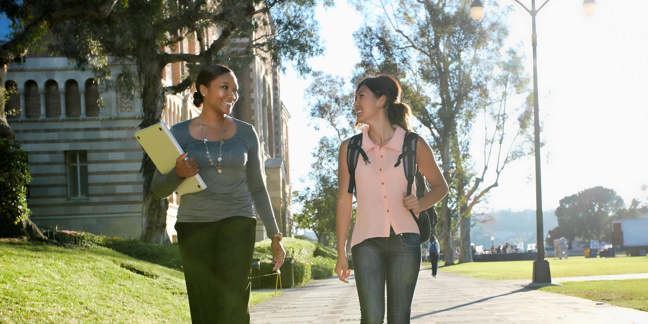 Two women walk on a college campus.