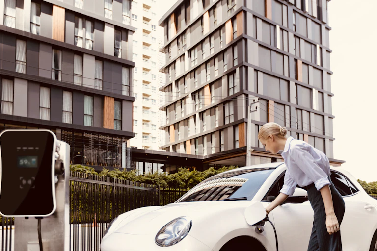 woman charges EV outside apartment block