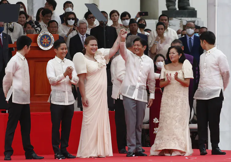 Philippines president Ferdinand 'Bongbong' Marcus, and his vice-president, Sara Duterte, clasp hands in a victory salte after breng sworn in to office in June 2022.