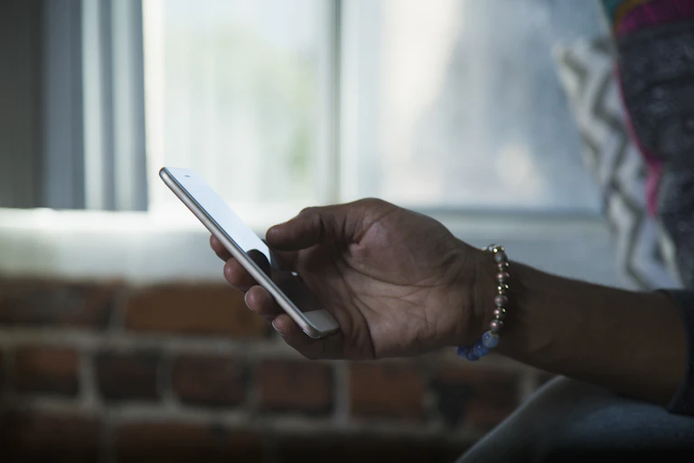 Black person's hand holding a cellphone
