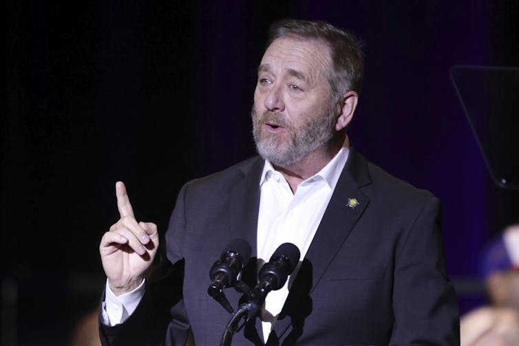 Yost speaking at a podium