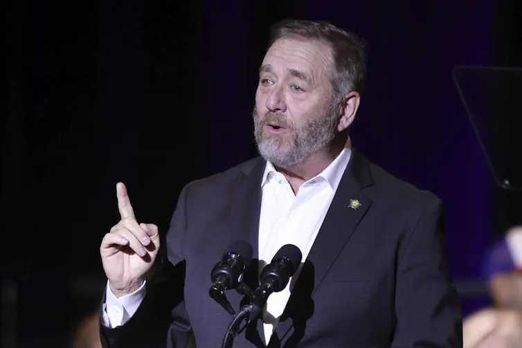 Yost speaking at a podium