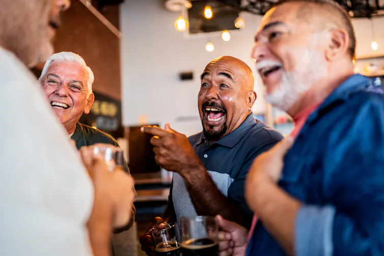 older men laughing together at a bar