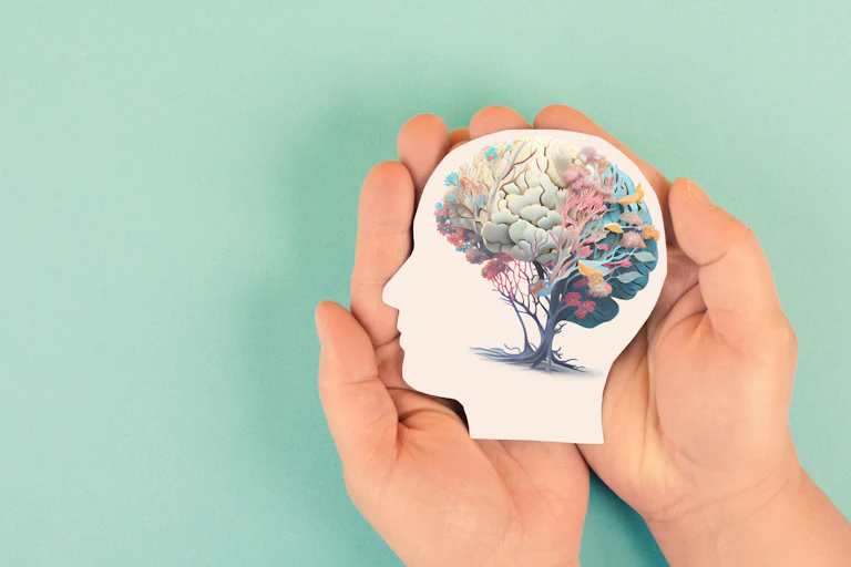Hands holding paper head, human brain with flowers