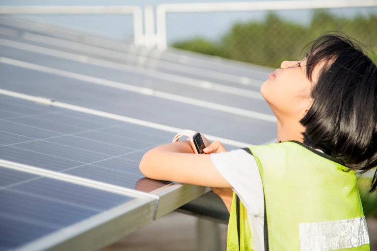 girl leans on solar panels